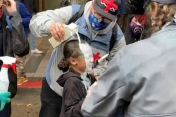 One man poured milk over the girl's head after she was allegedly pepper-sprayed by police (Image: evanmichael/Instagram)