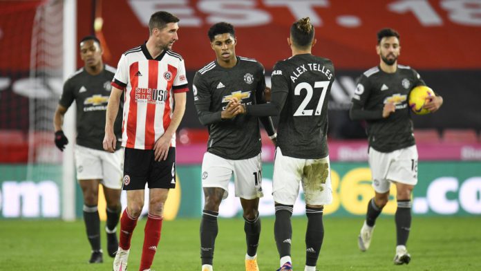 Marcus Rashford of Manchester United celebrates with team mate Alex Telles after scoring their sides first goal during the Premier League match between Sheffield United and Manchester United at Bramall Lane Image credit: Getty Images