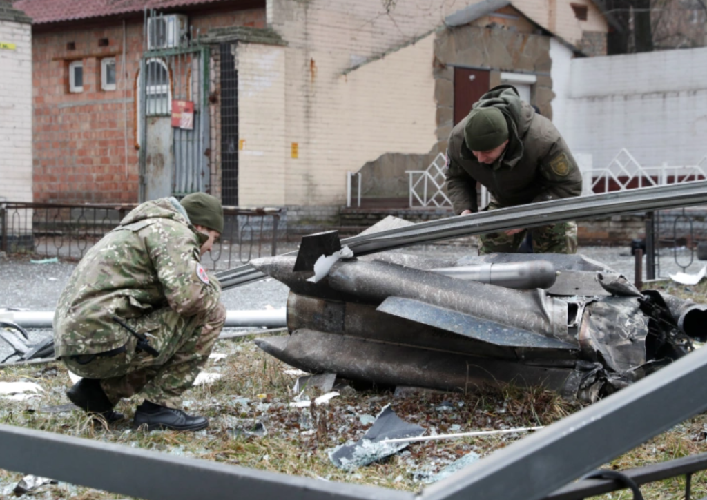 Police officers inspect the remains of a missile that fell in the street, after Russian President Vladimir Putin authorized a military operation in eastern Ukraine, in Kyiv, Ukraine February 24, 2022 [Valentyn Ogirenko/Reuters]