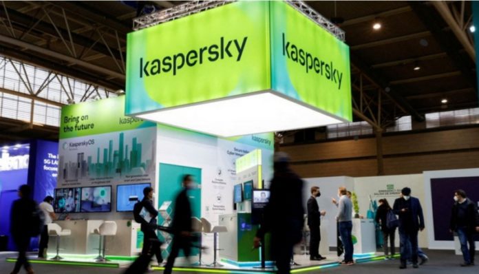 People walk next to Russian Kaspersky stand during the GSMA's 2022 Mobile World Congress (MWC), in Barcelona, Spain, March 2, 2022. REUTERS/ Albert Gea/File Photo