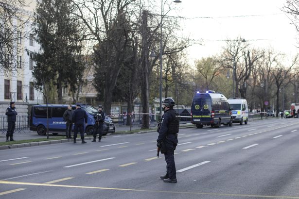 Police officers stand guard of the crime scene in Bucharest, Romania, outside the Russian embassy ( Image: REUTERS)