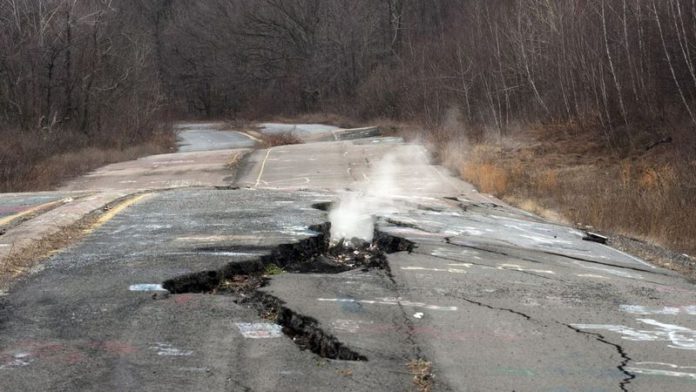 Smoke rises from a large crack in Route 61 caused by the ongoing underground fire in Centralia, Pennsylvania (Image: Don Emmert/AFP via Getty Images)