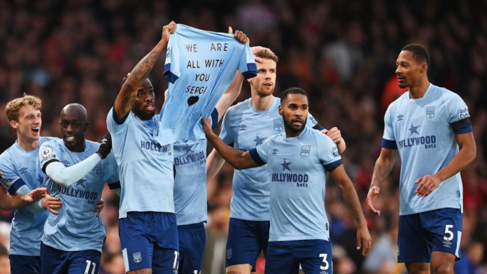 Ivan Toney of Brentford and teammates hold a shirt for former teammate Sergi Canos after scoring the team's first goal during the Premier League match between Arsenal FC and Brentford FC at Emirates Stadium on February 11, 2023 in London, England. Image credit: Getty Images