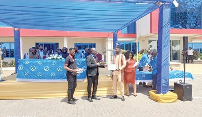 Prof. Alex Dodoo (2nd from left), Director-General, GSA, presenting a certificate to Atteh Adamtey, a certified electrical wiring professional, at the graduation ceremony