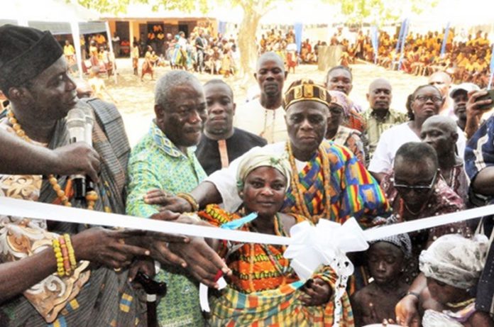 Kofi Dzamesi (2nd from left), CEO of Bui Power Authority, being assisted by some traditional rulers to perform the tape-cutting ceremony. Inset: The new classroom block