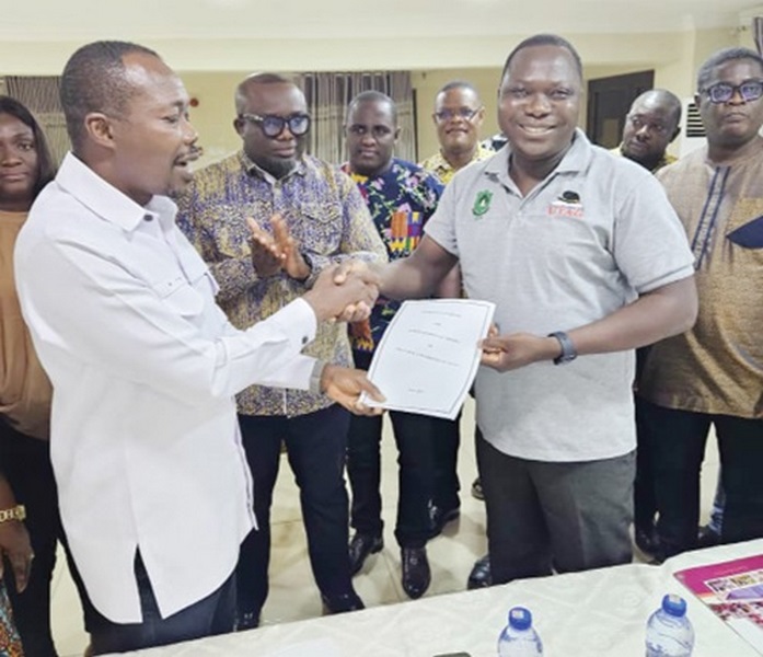 Benjamin Arthur (left), Chief Executive of FWSC, handing over the conditions of service to Prof. Mamudu Akudugu, UTAG National President