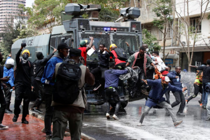 Demonstrators try to obstruct a police vehicle as police use water cannons to disperse protesters during a demonstration against Kenya's proposed finance bill 2024/2025 in Nairobi, Kenya, June 25, 2024. REUTERS/Monicah Mwangi
