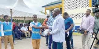 Dr Bawumia presenting a tablet to one of the students