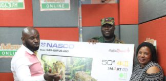 Adom FM Presenter Ampofo Adjei presenting 50” smart android NASCO TV to Christiana Oduman in 1st monthly draw