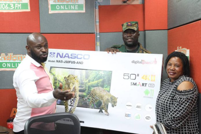 Adom FM Presenter Ampofo Adjei presenting 50” smart android NASCO TV to Christiana Oduman in 1st monthly draw