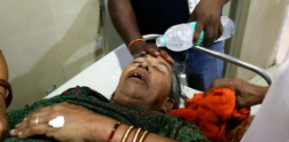 A staff member pours water on the face of a patient suffering from heat stroke in a hospital in Varanasi