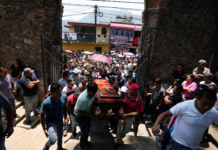People carry a coffin that contains the remains of a man slain in a mass shooting into a church for a funeral service in Huitzilac, Mexico, on May 14. Fernando Llano/AP