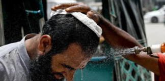 Getty Images In Karachi, a man has his face sprayed on to cool off during a heat wave