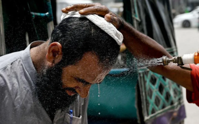 Getty Images In Karachi, a man has his face sprayed on to cool off during a heat wave