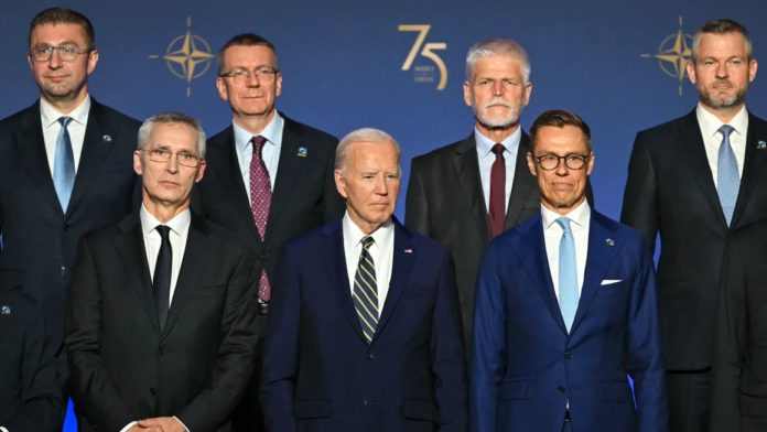 President Joe Biden, flanked by NATO Secretary General Jens Stoltenberg, left, and President of Finland Alexander Stubbs, right, stands with NATO leaders for a group photo during the NATO 75th Anniversary Celebratory Event at the Mellon Auditorium in Washington, DC, on July 9. Saul Loeb/AFP/Getty Images